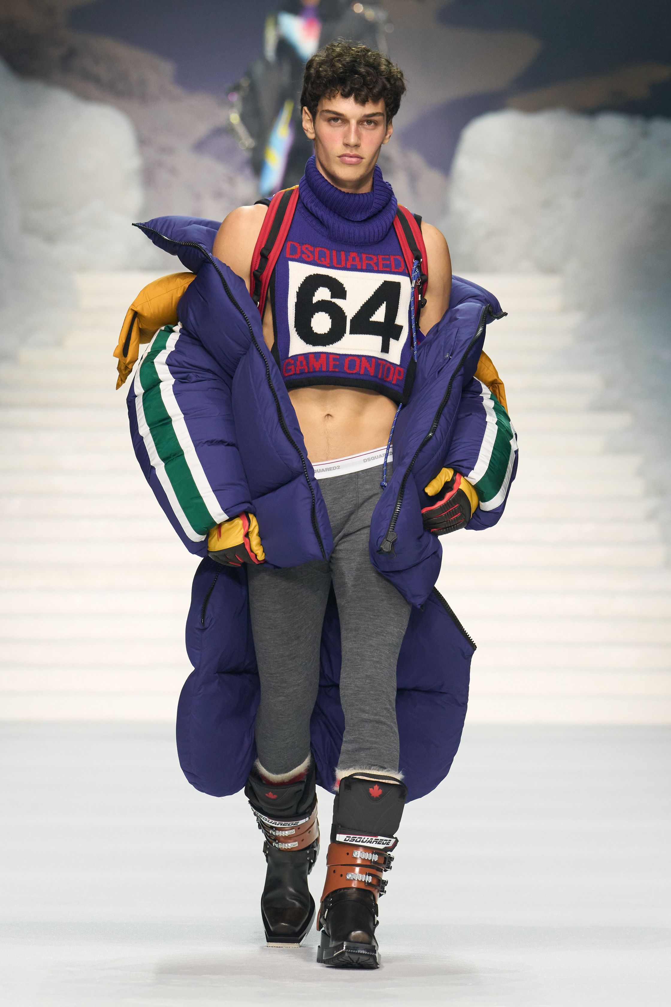 Dsquared2 2026秋冬以夸张的滑雪场景为背景，将加拿大户外精神、Y2K 性感与舞台化时装推至极致。羽绒、毛皮、紧身牛仔与夸张比例不断叠加，身体成为视觉焦点，性感、力量与炫耀被无限放大。这不是现实主义的衣橱，而是一场关于冒险、欲望与表演的时尚狂欢，张扬而直接，忠于品牌一贯的高能量叙事-顽石频道趋势研究